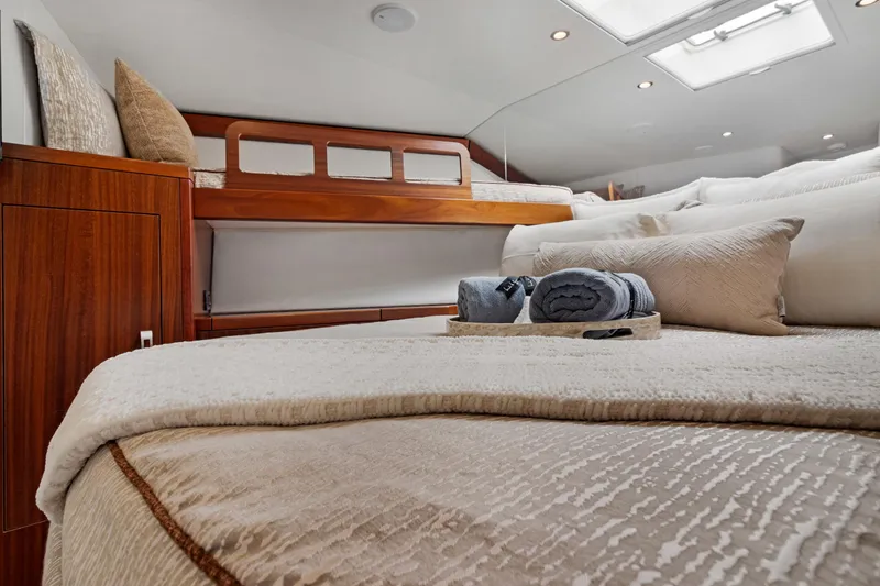  Yacht Photos Pics Luxurious cabin interior of 2016 Hatteras 63GT yacht with cozy bedding and elegant wood finish.