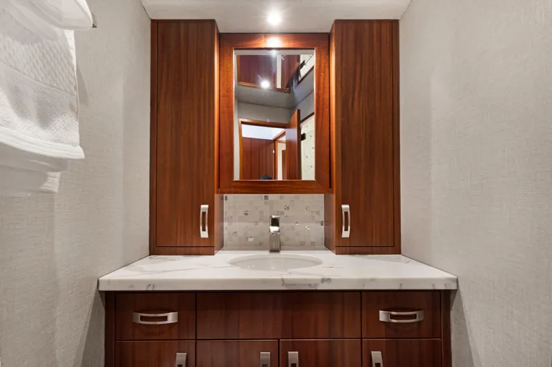  Yacht Photos Pics Luxurious bathroom vanity on 2016 Hatteras 63GT yacht with wood cabinetry and marble countertop.
