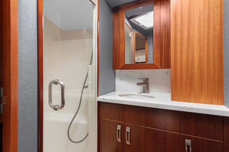  Yacht Photos Pics Luxurious bathroom in 2016 Hatteras 63GT yacht with wood cabinetry and glass shower.