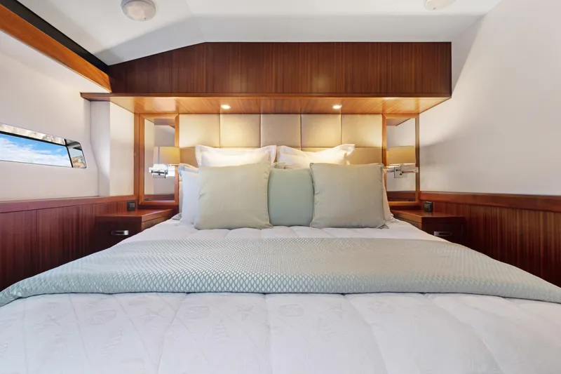  Yacht Photos Pics Luxurious bedroom interior of 2016 Hatteras 63GT yacht with elegant wood paneling.