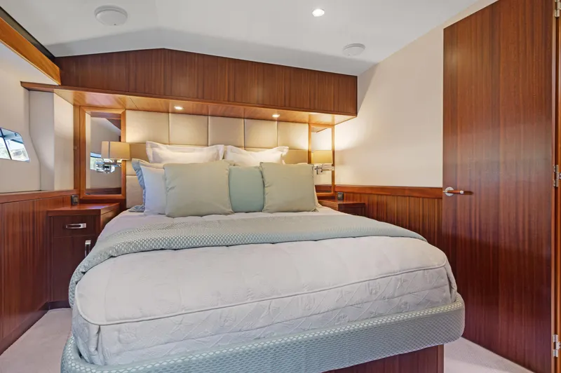  Yacht Photos Pics Luxurious bedroom interior of 2016 Hatteras 63GT yacht with elegant wood finishes.