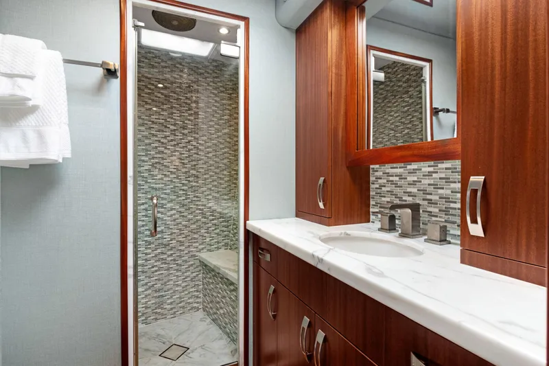  Yacht Photos Pics Luxurious bathroom in 2016 Hatteras 63GT yacht with marble countertop and glass shower.
