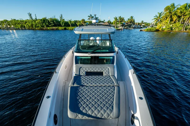 Chye-lukh Yacht Photos Pics 2021 Axopar 37 boat on serene water with lush greenery and palm trees.