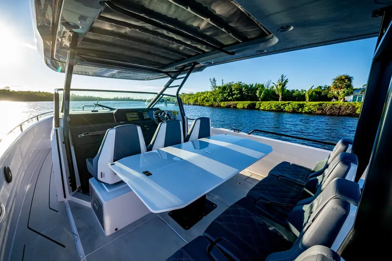 Chye-lukh Yacht Photos Pics 2021 Axopar 37 boat interior with seating and table, cruising on a sunny day.