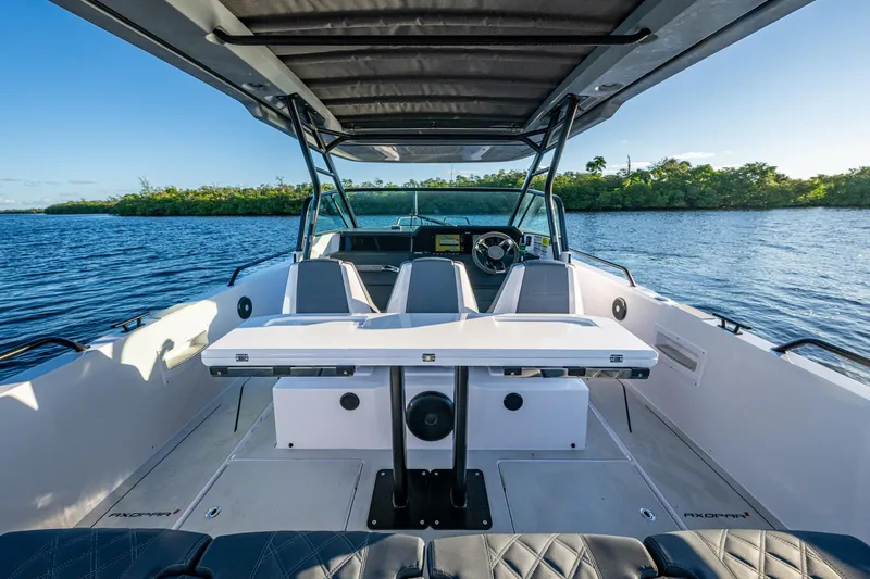 Chye-lukh Yacht Photos Pics 2021 Axopar 37 boat interior with seating and table on a sunny day.