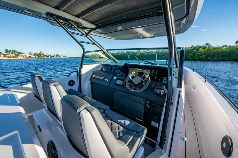 Chye-lukh Yacht Photos Pics 2021 Axopar 37 boat interior with modern helm and dual seating on a sunny day.