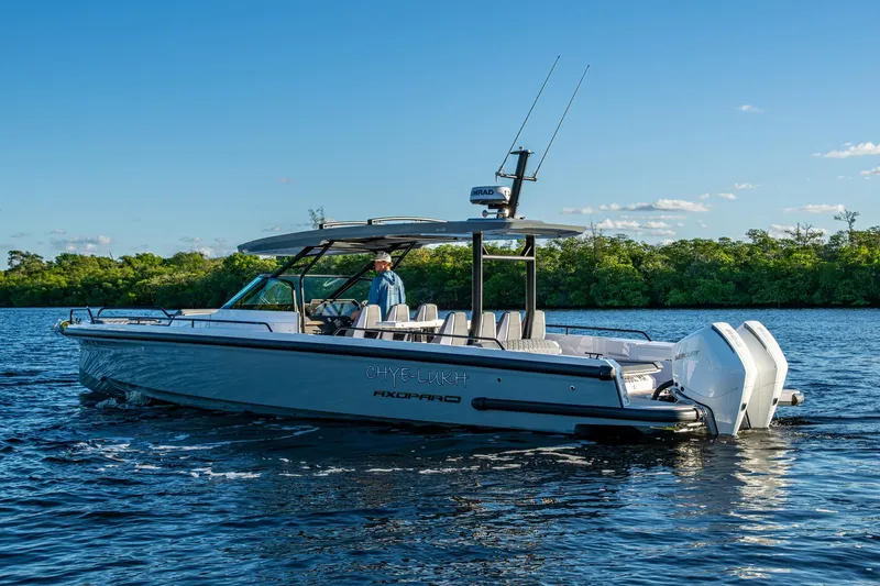 Chye-lukh Yacht Photos Pics 2021 Axopar 37 boat cruising on a serene lake with lush green shoreline.