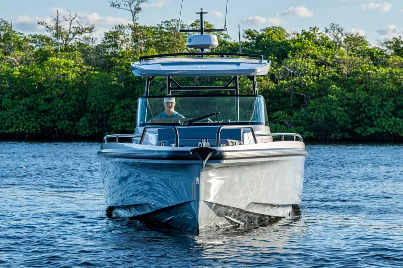 Chye-lukh Yacht Photos Pics 2021 Axopar 37 boat cruising on a calm lake with lush greenery in the background.