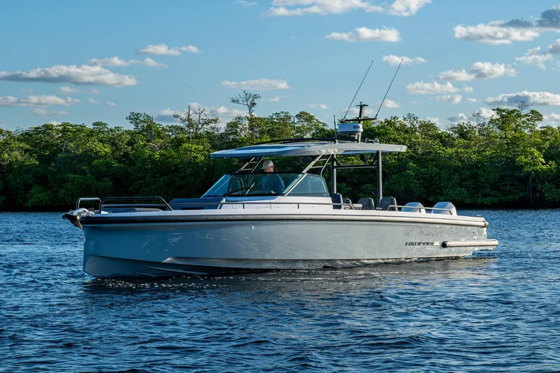 Chye-lukh Yacht Photos Pics 2021 Axopar 37 boat cruising on a serene lake with lush greenery.