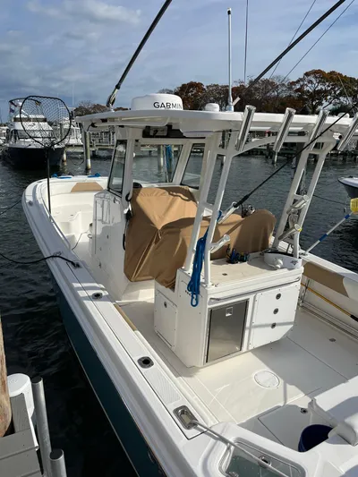  Yacht Photos Pics 2022 Edgewater 285CC boat docked, featuring fishing equipment and a covered console.