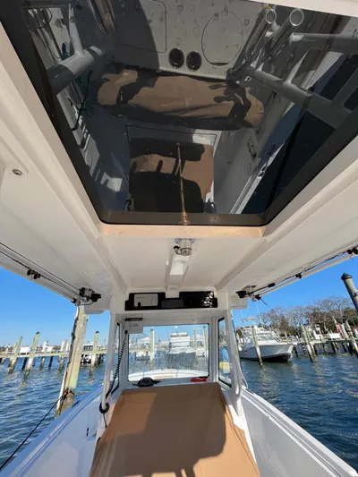  Yacht Photos Pics 2022 Edgewater 285CC boat interior, featuring sleek design and spacious layout at a marina.