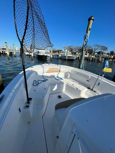  Yacht Photos Pics 2022 Edgewater 285CC boat docked at marina, clear blue sky, fishing net visible.