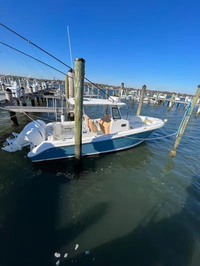  Yacht Photos Pics 2022 Edgewater 285CC boat docked in a marina under clear blue skies.