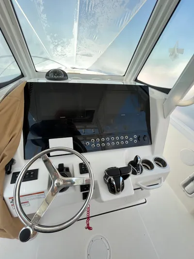  Yacht Photos Pics 2022 Edgewater 285CC boat dashboard with steering wheel and controls.