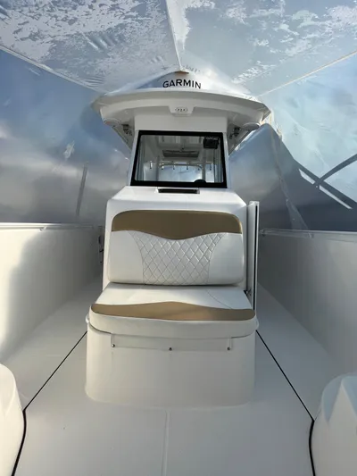  Yacht Photos Pics 2022 Edgewater 285CC boat interior with cushioned seating and Garmin equipment.