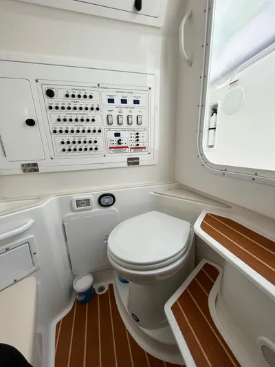  Yacht Photos Pics 2022 Edgewater 285CC boat interior with control panel and toilet, featuring wood accents.