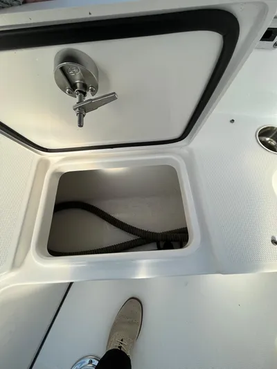  Yacht Photos Pics 2022 Edgewater 285CC boat storage compartment with open hatch and visible hose.