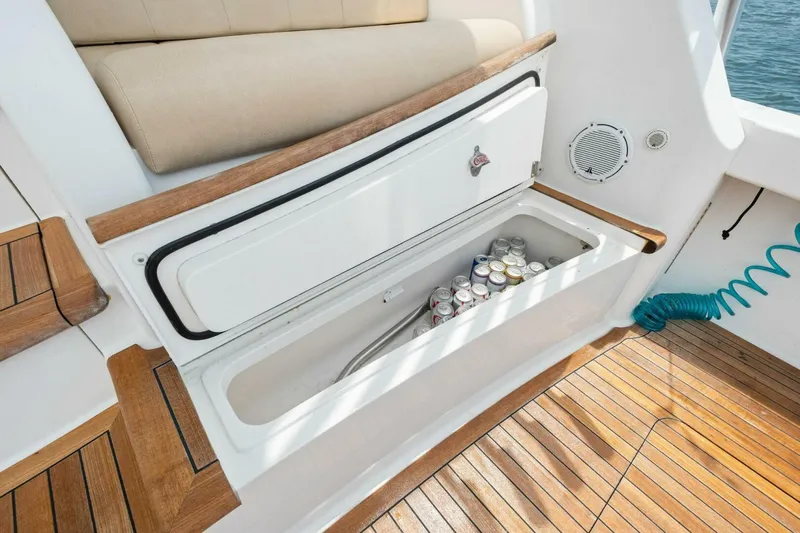 Terrabbean Yacht Photos Pics Built-in cooler with drinks on 2015 Viking 52 Open yacht, featuring teak flooring and seating.