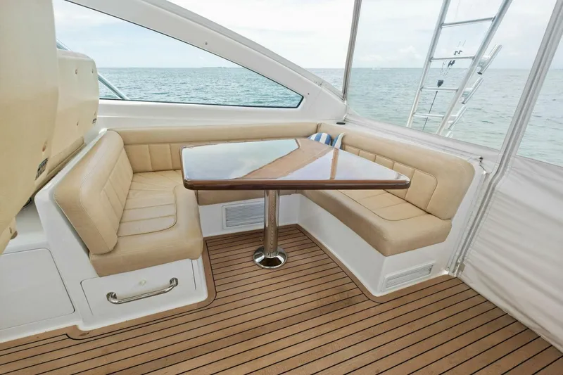 Terrabbean Yacht Photos Pics Interior of 2015 Viking 52 Open yacht with beige seating and wooden table.
