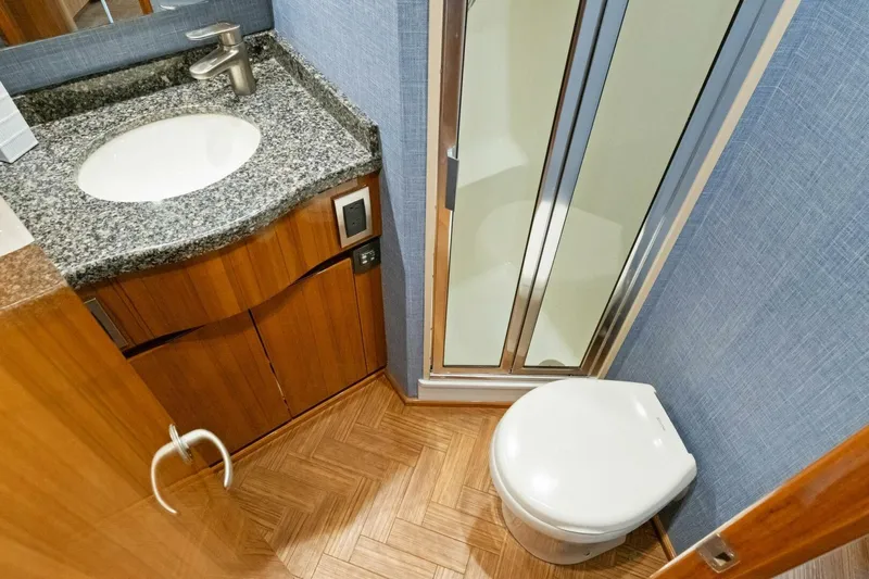 Terrabbean Yacht Photos Pics 2015 Viking 52 Open yacht bathroom with granite countertop, sink, shower, and toilet.