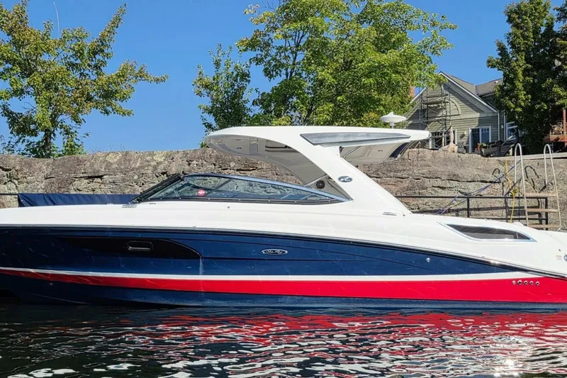  Yacht Photos Pics 2019 Sea Ray 350 SLX boat docked by rocky shoreline, under clear blue sky.