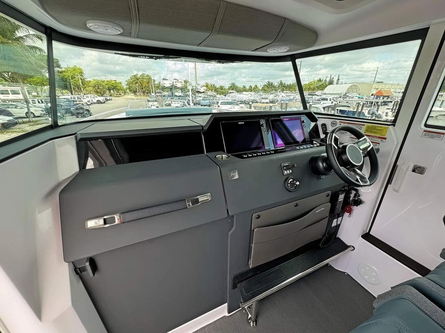 2024 Axopar 37XC CROSS CABIN helm with modern controls and panoramic windows.