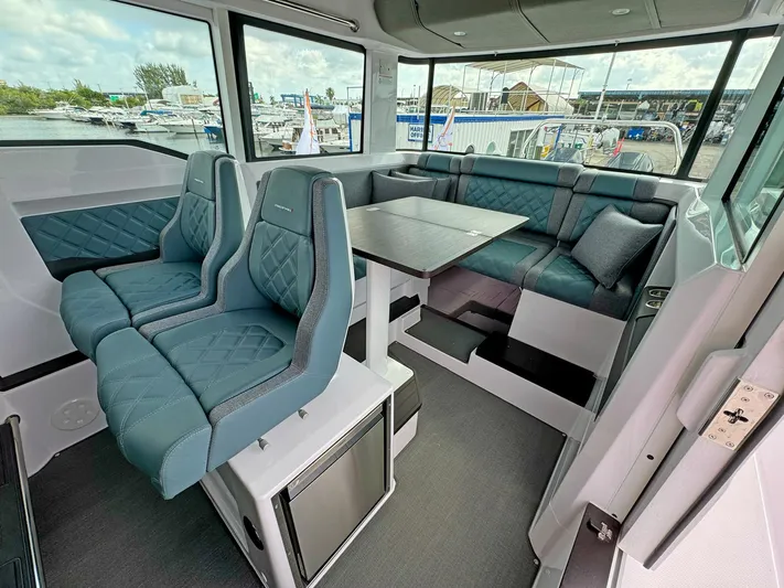  Yacht Photos Pics 2024 Axopar 37XC CROSS CABIN interior with blue seating and dining area.