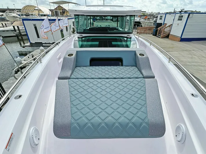  Yacht Photos Pics 2024 Axopar 37XC CROSS CABIN boat with spacious deck and luxurious seating at a marina.