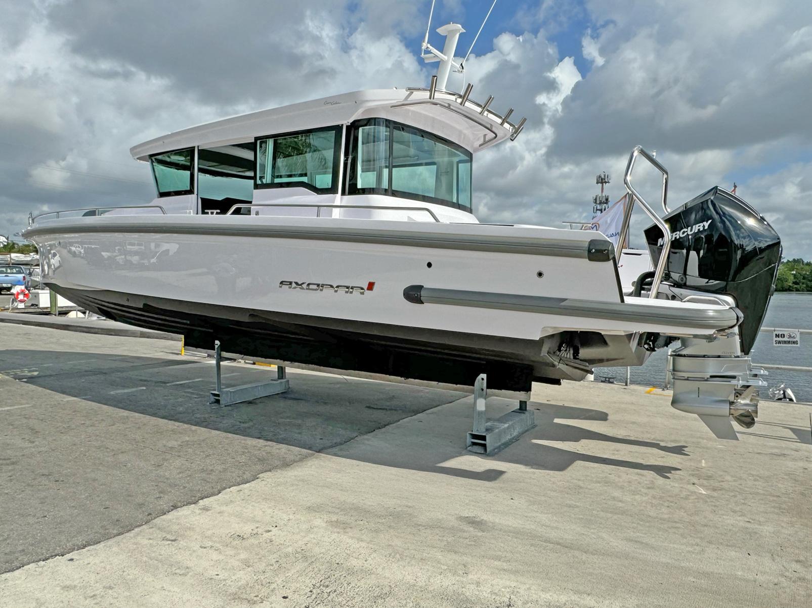 2024 Axopar 37XC CROSS CABIN boat on display at a marina.