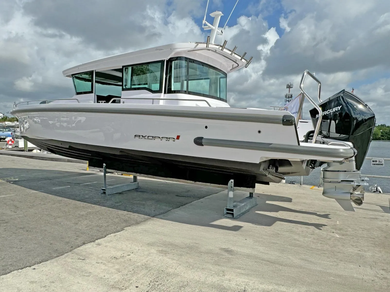 2024 Axopar 37XC CROSS CABIN boat on display at a marina.