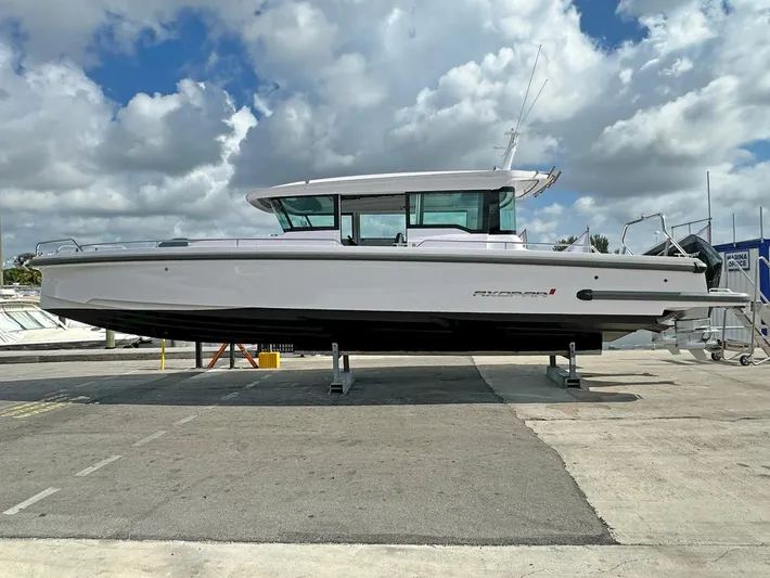  Yacht Photos Pics 2024 Axopar 37XC CROSS CABIN boat on display under a cloudy sky.
