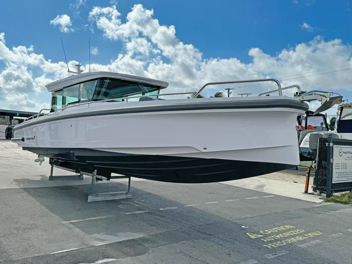  Yacht Photos Pics 2024 Axopar 37XC CROSS CABIN boat displayed outdoors under a blue sky.