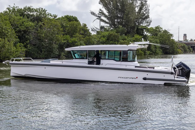  Yacht Photos Pics 2024 Axopar 37XC CROSS CABIN boat cruising on a calm river.