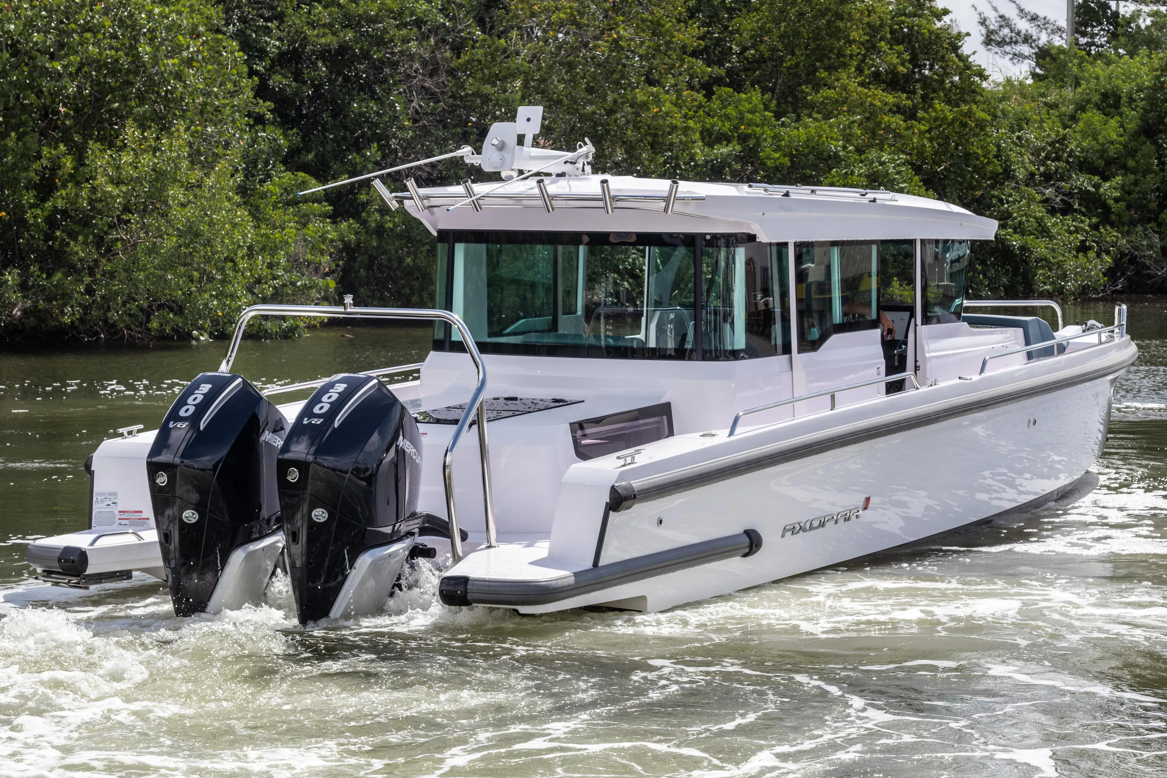 2024 Axopar 37XC CROSS CABIN boat with dual engines cruising on water.