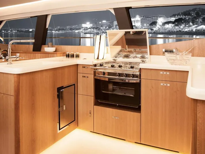  Yacht Photos Pics Luxurious kitchen interior of 2025 Moody 54 DS yacht with modern appliances and wood finish.