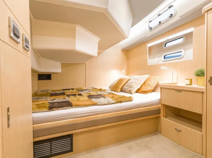  Yacht Photos Pics Luxurious cabin interior of 2025 Moody 54 DS yacht with cozy bed and modern decor.