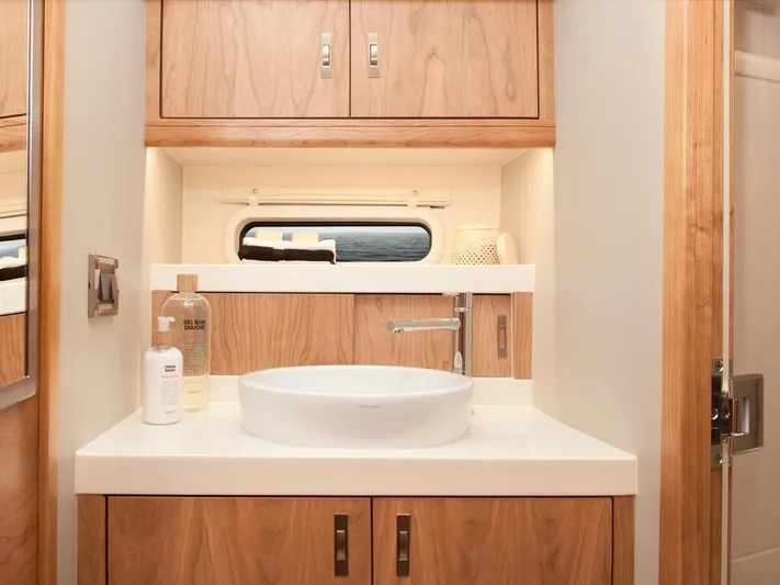  Yacht Photos Pics Modern bathroom interior of 2025 Moody 54 DS yacht with wooden cabinetry and sleek sink design.
