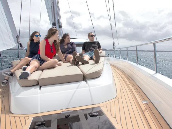  Yacht Photos Pics Four people relaxing on a 2025 Moody 54 DS yacht deck under cloudy skies.