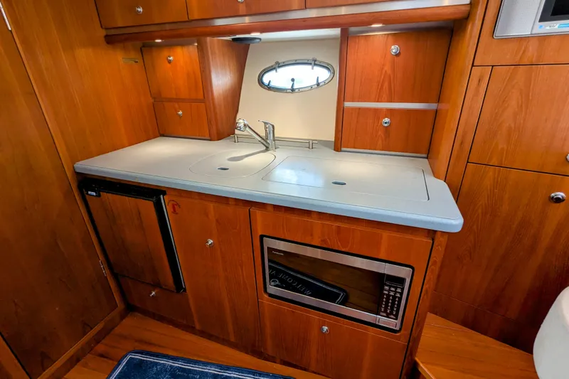  Yacht Photos Pics 2005 Tiara Yachts 3200 Open galley with wood cabinetry, sink, and microwave.