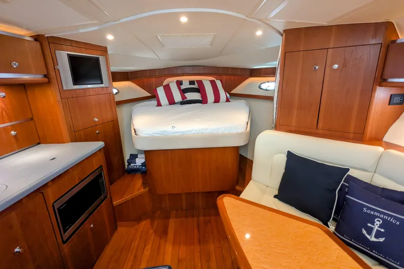  Yacht Photos Pics Luxurious 2005 Tiara Yachts 3200 Open cabin interior with bed, seating, and wooden cabinetry.