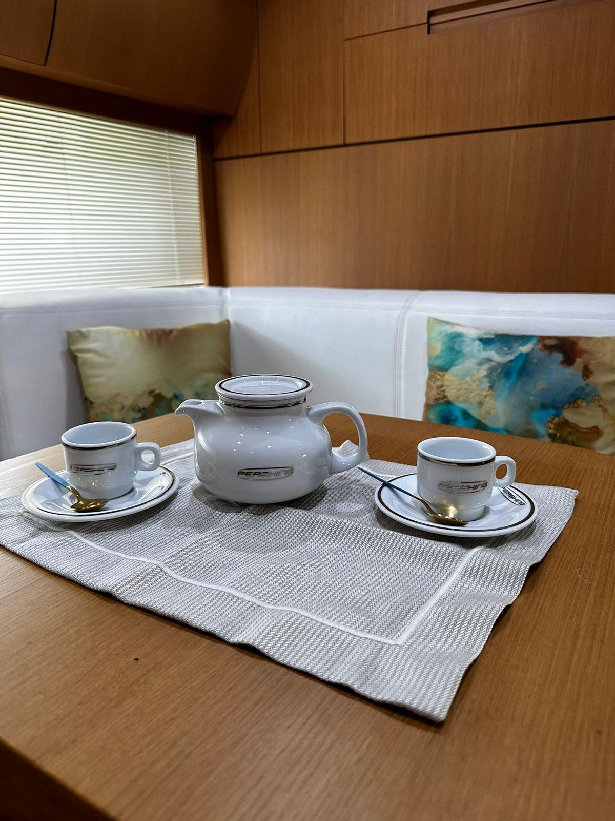 Tea set on wooden table inside 2009 Pershing 56 yacht cabin.
