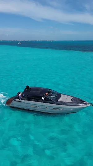 Lupo Yacht Photos Pics Luxury 2009 Pershing 56 yacht cruising in clear turquoise waters under a blue sky.