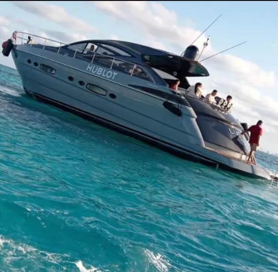 Lupo Yacht Photos Pics Luxury 2009 Pershing 56 yacht on turquoise waters, with people enjoying the deck.