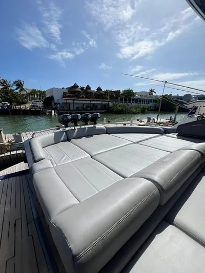 Lupo Yacht Photos Pics 2009 Pershing 56 yacht with spacious sunbathing deck, docked by waterfront homes.