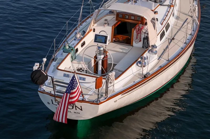 Loon Yacht Photos Pics 1988 Hinckley Sou'wester 42 sailboat on calm water, displaying American flag.