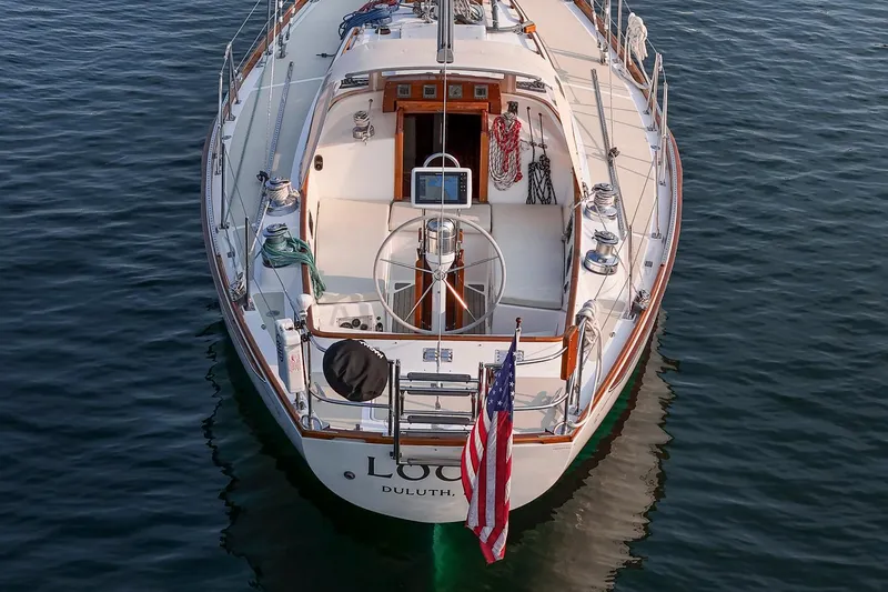 Loon Yacht Photos Pics 1988 Hinckley Sou'wester 42 sailboat on calm water, rear view with American flag.