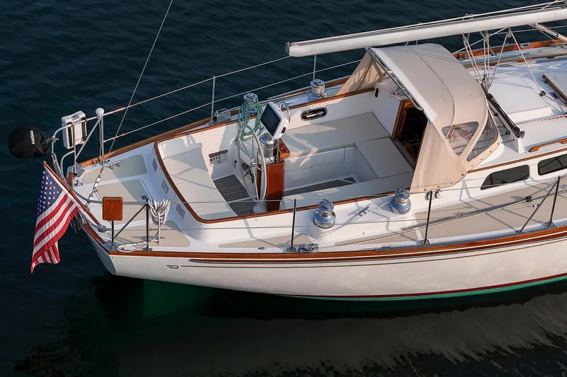 Loon Yacht Photos Pics 1988 Hinckley Sou'wester 42 sailboat with American flag, docked on calm water.