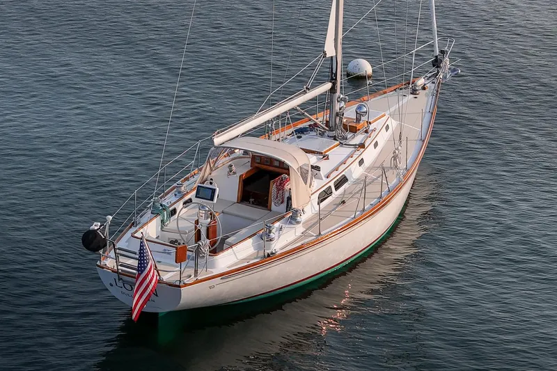Loon Yacht Photos Pics 1988 Hinckley Sou'wester 42 sailboat on calm water, displaying American flag.