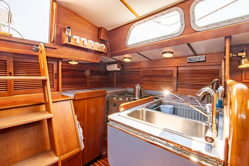 Loon Yacht Photos Pics Interior of 1988 Hinckley Sou'wester 42 sailboat, featuring wooden cabinetry and stainless steel sink.