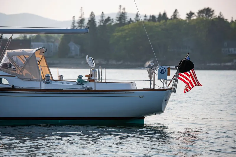 Loon Yacht Photos Pics 1988 Hinckley Sou'wester 42 sailboat on calm water, American flag waving.